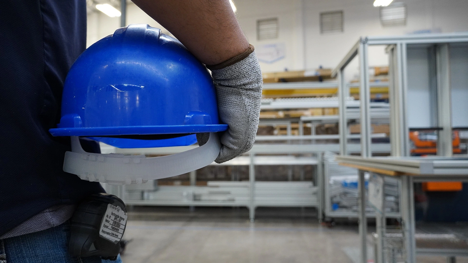 Trabajador sosteniendo un casco azul de seguridad industrial